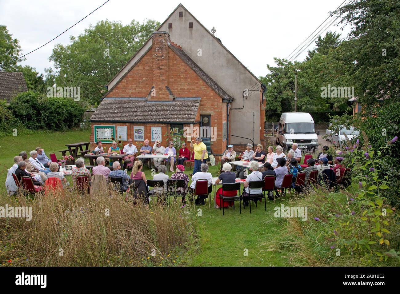 Church group holding outdoor service in Three Bees Community wildlife garden behind Mickleton Methodist Church, Chipping Campden, UK Stock Photo