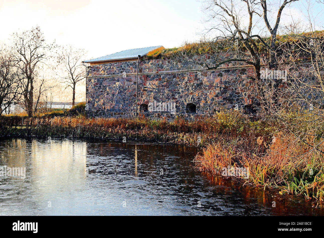 Fortifications of Suomenlinna by a small ice covered pond at winter sunset. Digital art from original photo. Suomenlinna is a UNESCO World Heritage si Stock Photo