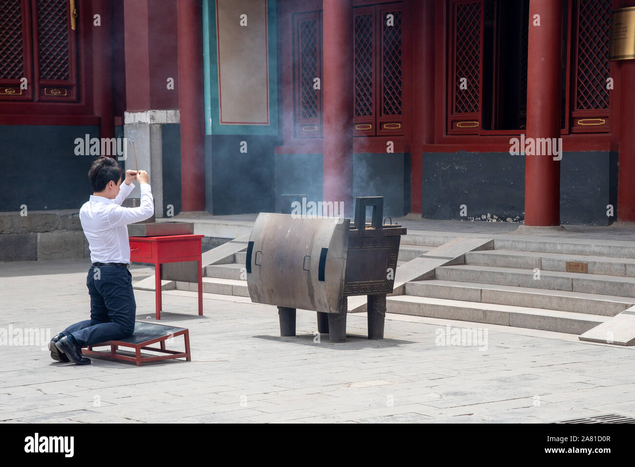 Beijing, China, June 8 2018 : Religious man praying at the Lama temple which is the biggest Tibetan Buddhist temple in Beijing, China Stock Photo