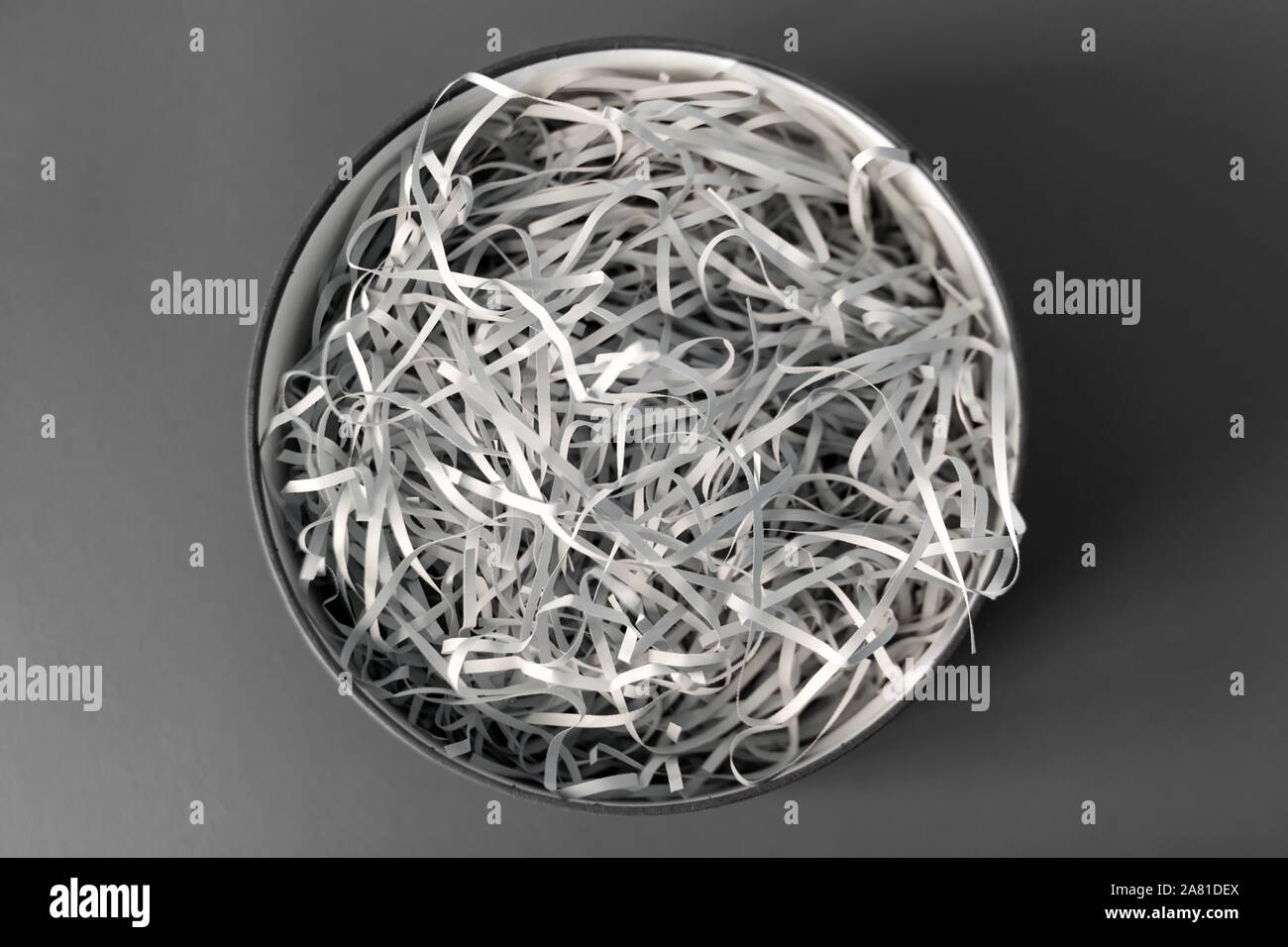 Opened gift box with decorative straw, filler, shavings, paper ribbons