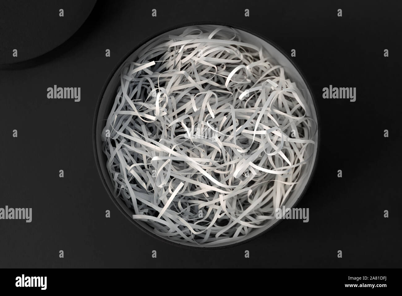 Opened gift box with decorative straw, filler, shavings, paper ribbons