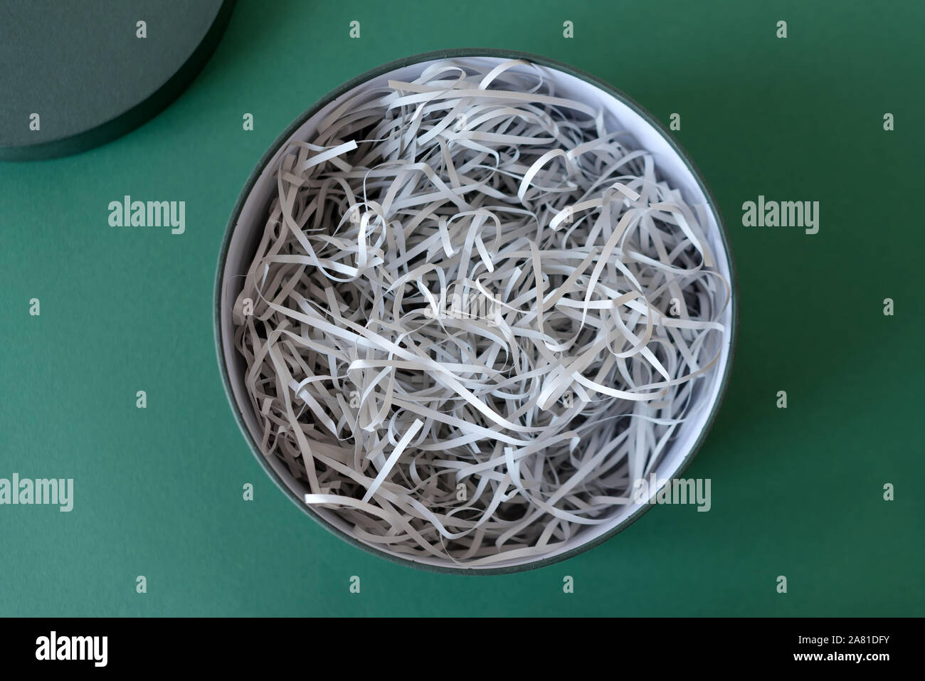 Opened gift box with decorative straw, filler, shavings, paper ribbons