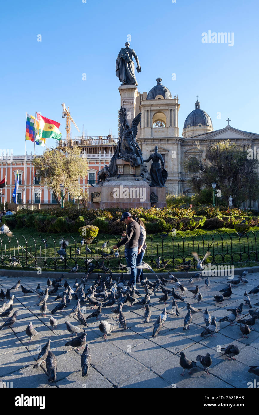 Daily life scene with local people feeding pigeons on the centric Plaza Murillo in the Historic District of La Paz, Bolivia Stock Photo