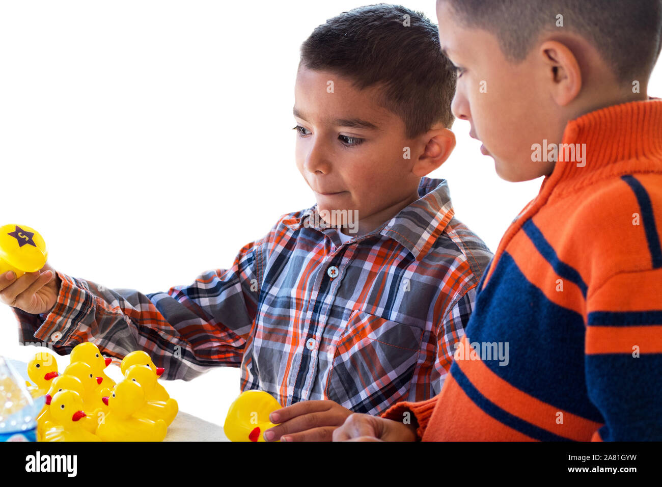 Two brothers playing a carnival game with floating ducks Stock Photo