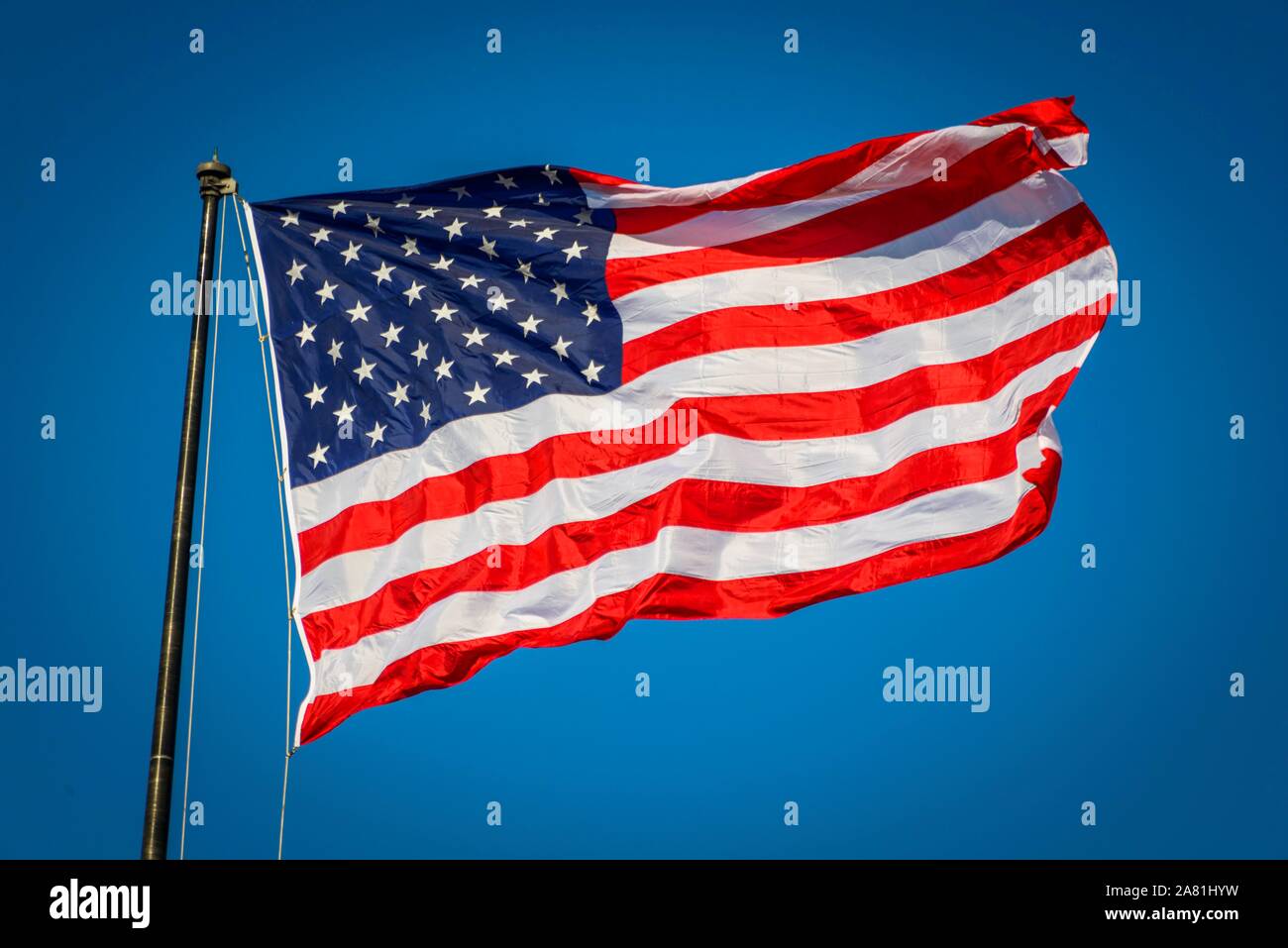 American flag, national flag, US-American flag blowing in the wind against a blue sky, USA Stock Photo