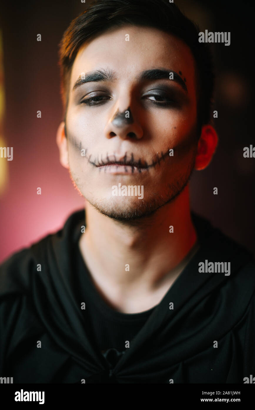 Young man with Halloween make-up looks at the camera Stock Photo