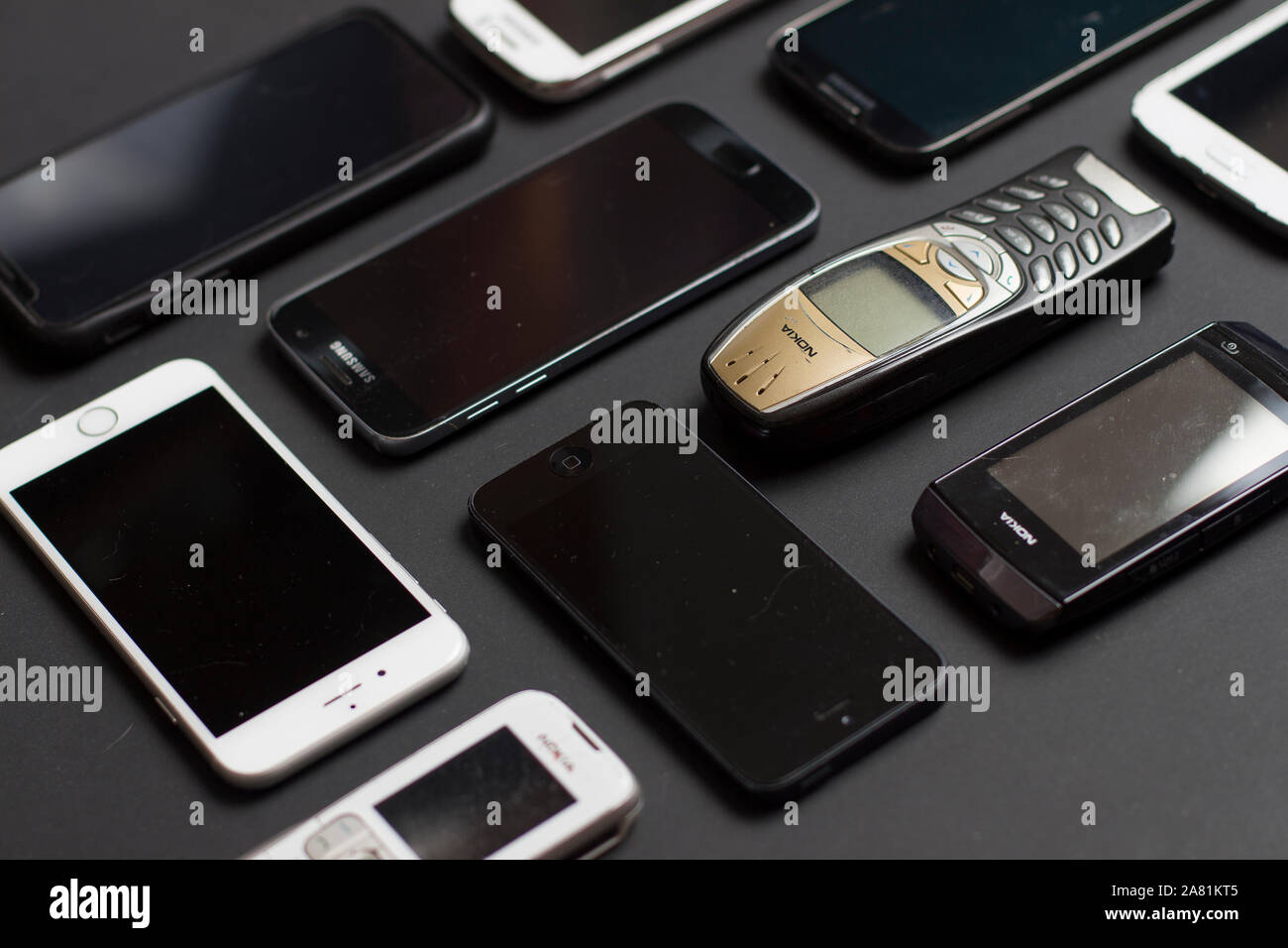 Close up on smartphones of all ages resting on a black background Stock Photo