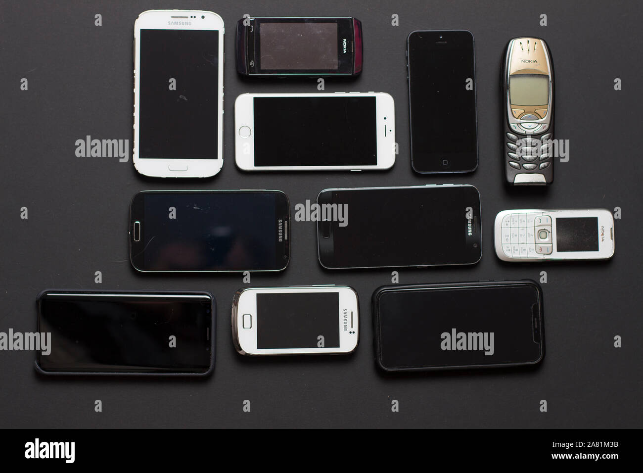 Close up on smartphones of all ages resting on a black background Stock Photo