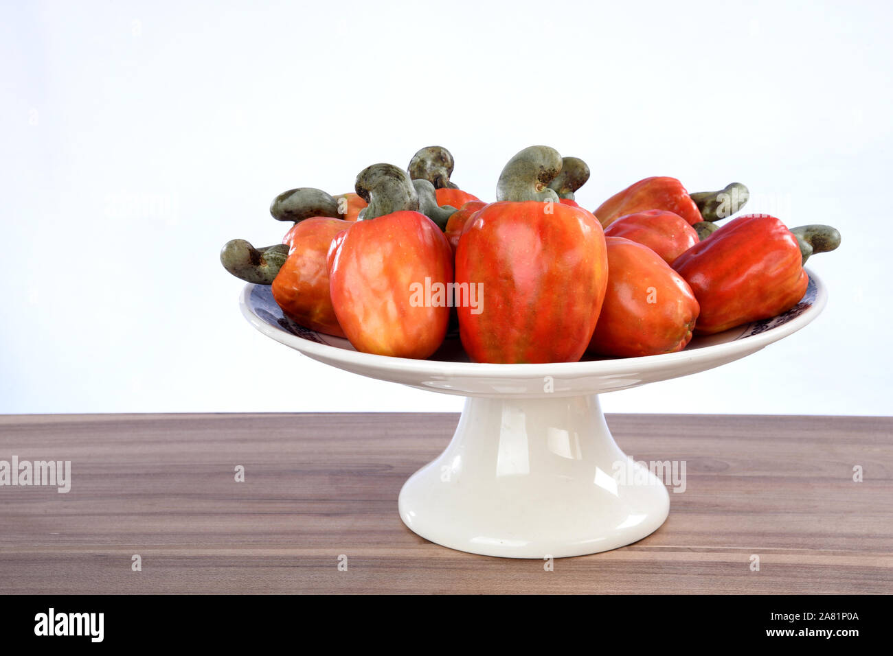 Cashew nuts isolated with glass of fruit juice on white background