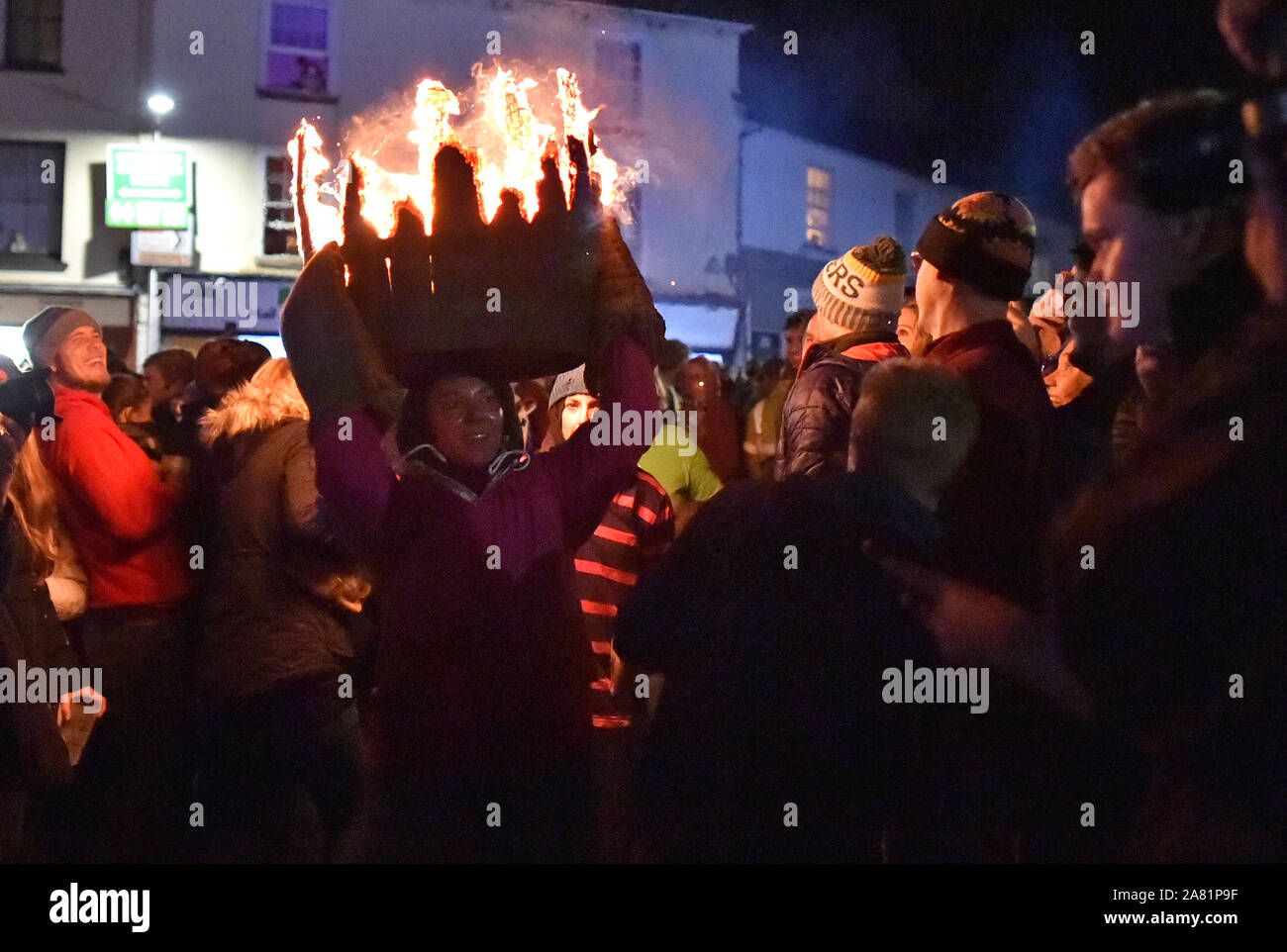 Participants in the village of Ottery St Mary in Devon carry traditional burning tar barrels through the streets of the village on bonfire night. Stock Photo