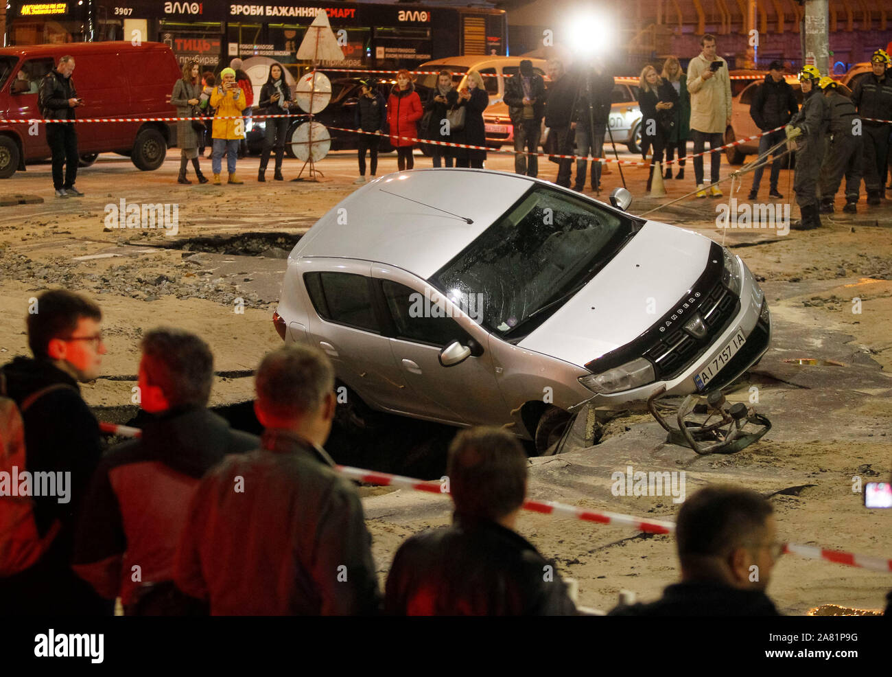 A car is seen in a hole of a collapsed road during a pipeline accident in central Kiev.As a result of damage of the trunk pipeline on a road in downtown of Kiev two cars fell into the damage zone, the drivers were not injured, reports the site of the Kiev city state administration. Stock Photo
