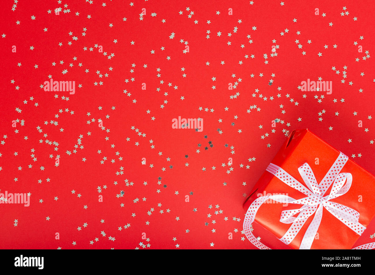Festive background , gift box with ribbon and bow on a red background ...
