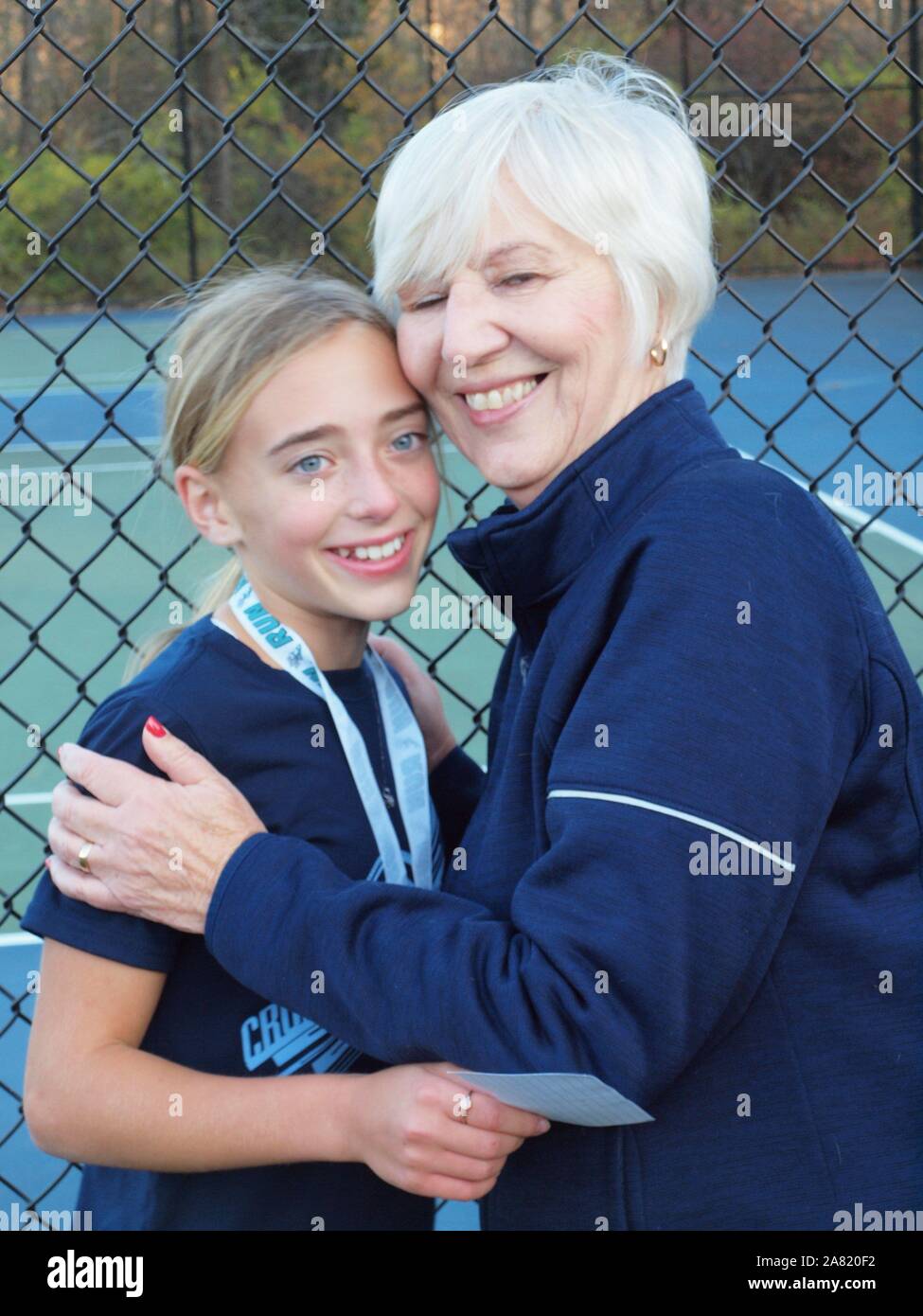Grandmother congratulating granddaughter after cross-country race in New Jersey middle school. Stock Photo