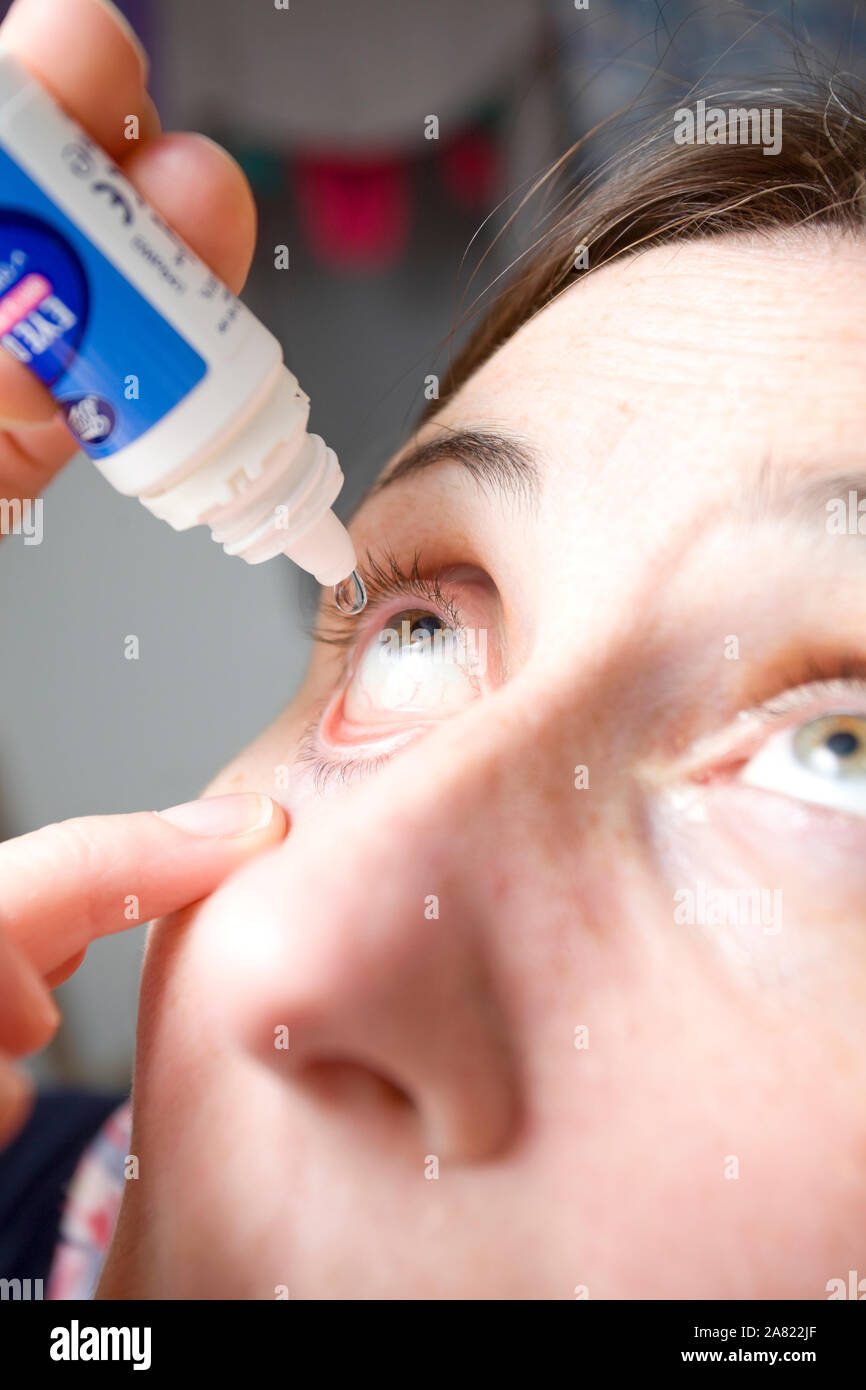 Women applying eye drops into her eye Stock Photo