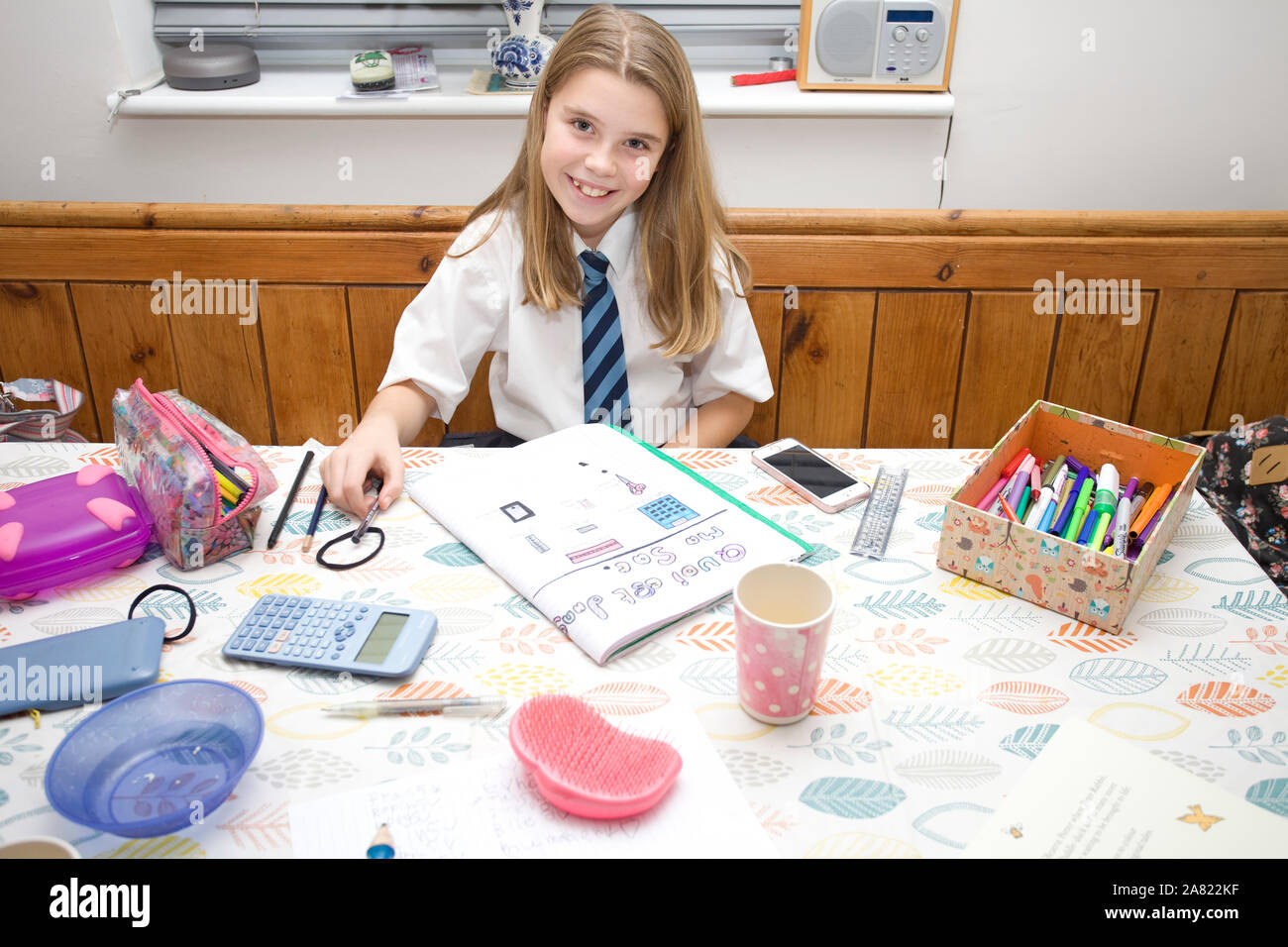 School girl doing french homework at kitchen table Stock Photo
