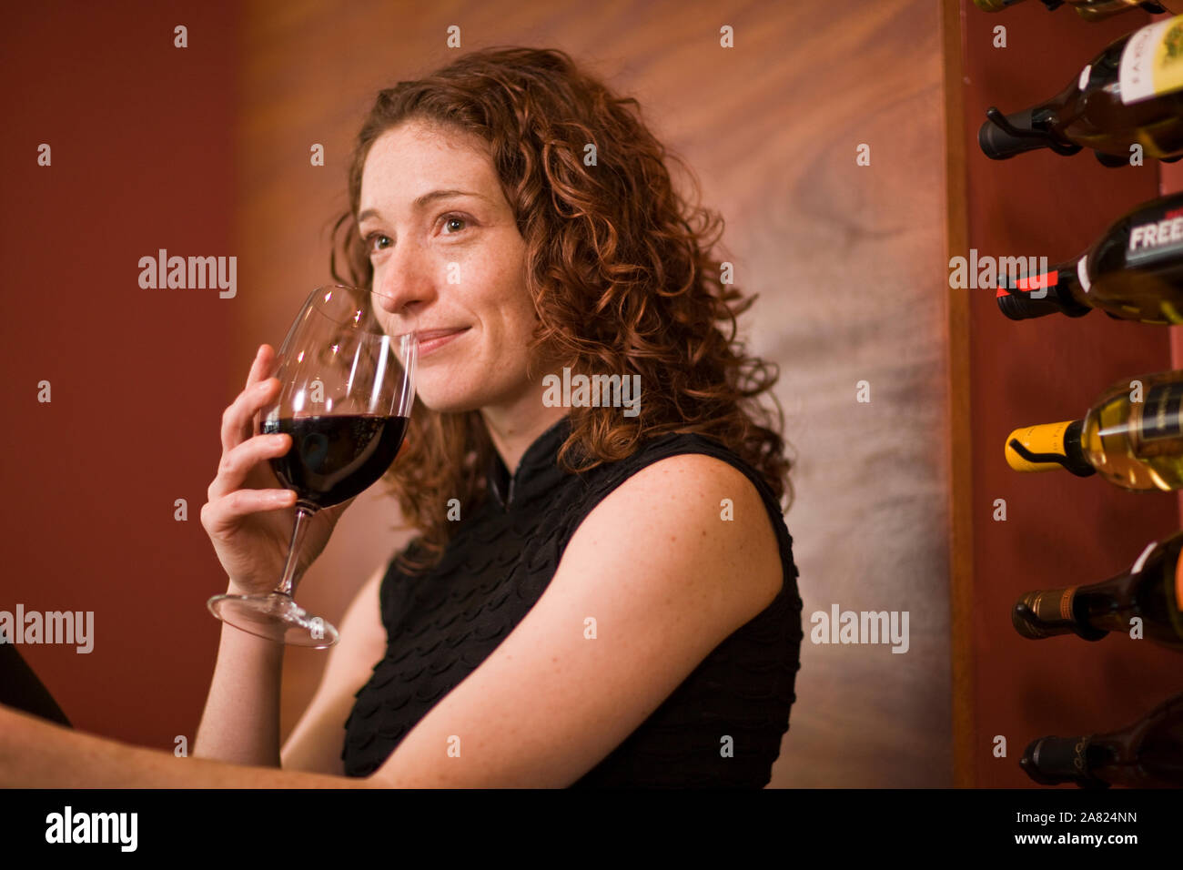 A red haired woman drinking wine Stock Photo