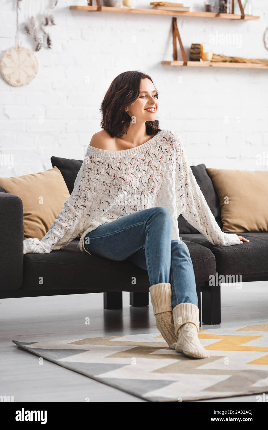 happy beautiful woman sitting on sofa in cozy living room Stock Photo ...