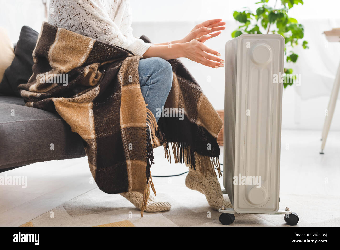 Cropped View Of Girl With Blanket Warming Up With Heater In