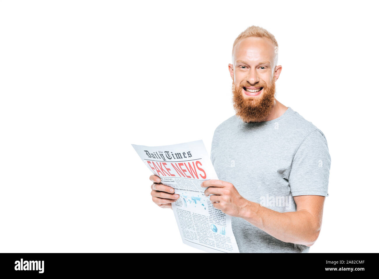 bearded smiling man reading newspaper with fake news, isolated on white Stock Photo