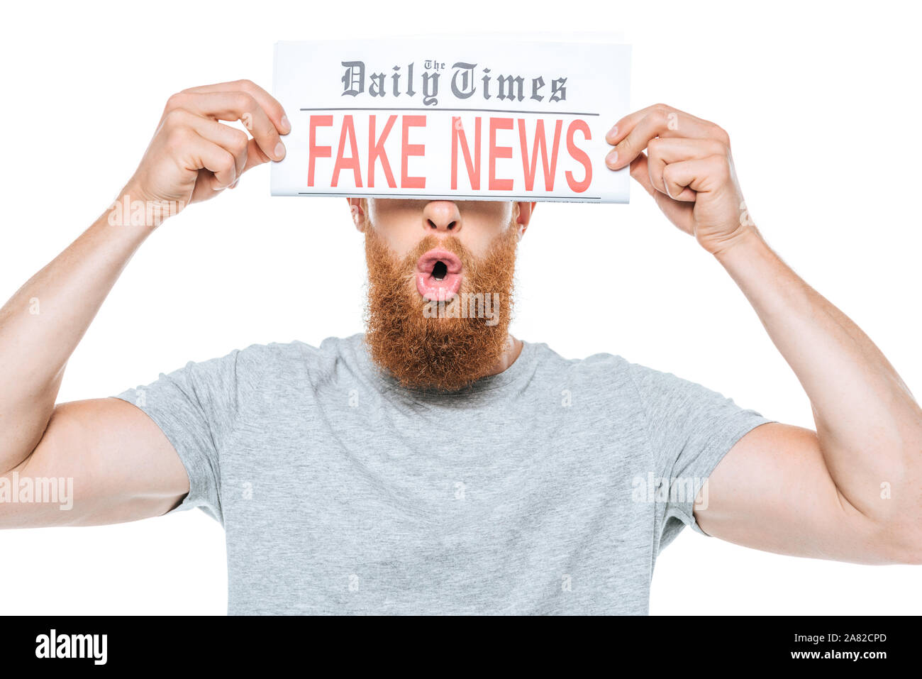 shocked bearded man holding newspaper with fake news in front of eyes ...