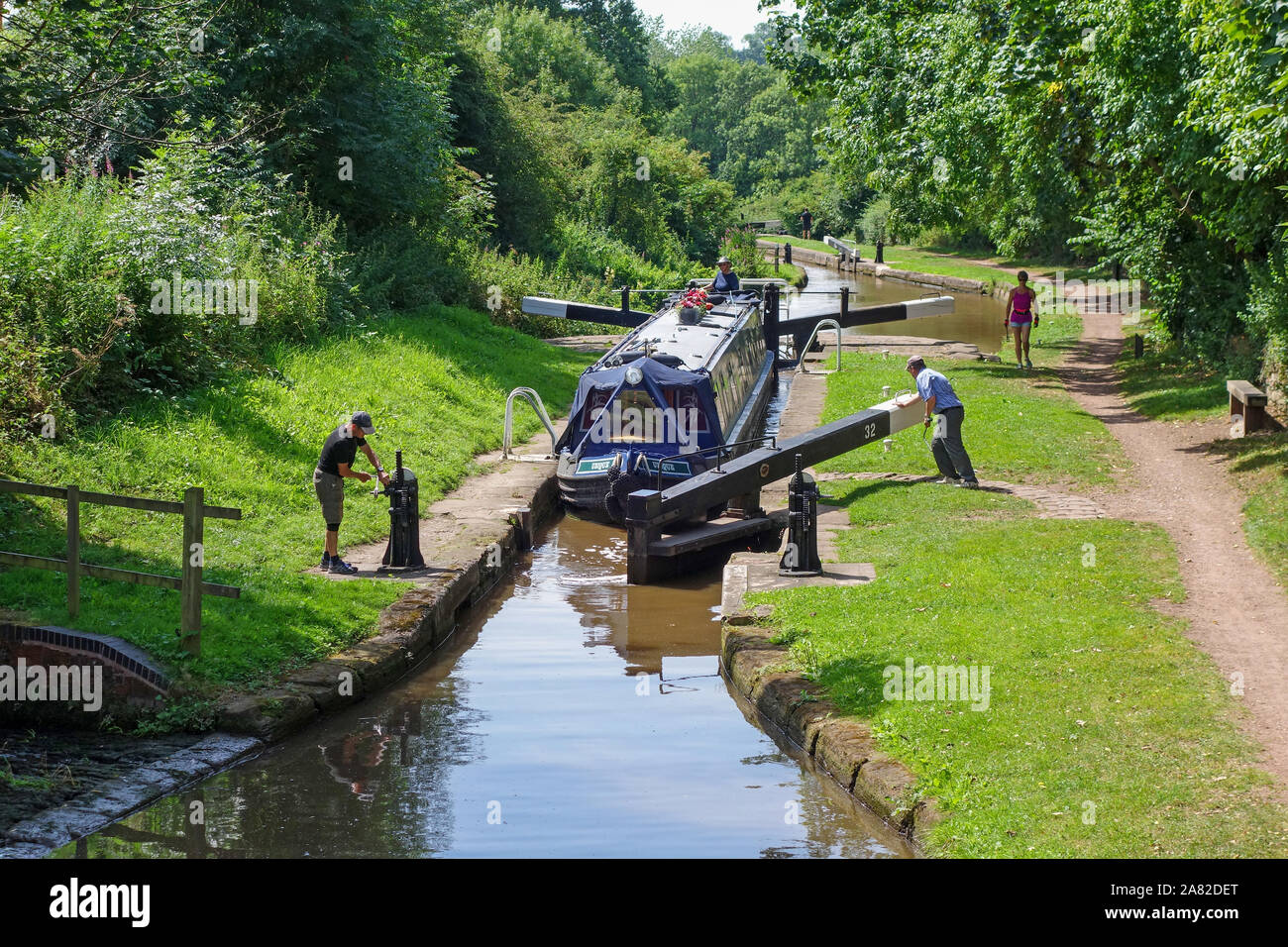 A canal boat or barge passing through Meaford House Lock on the Trent and Mersey canal at Meaford, near Stone, Staffordshire, England, UK Stock Photo