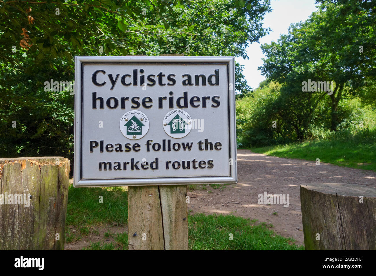 A sign saying 'Cyclists and horse riders please follow the marked routes' Stock Photo