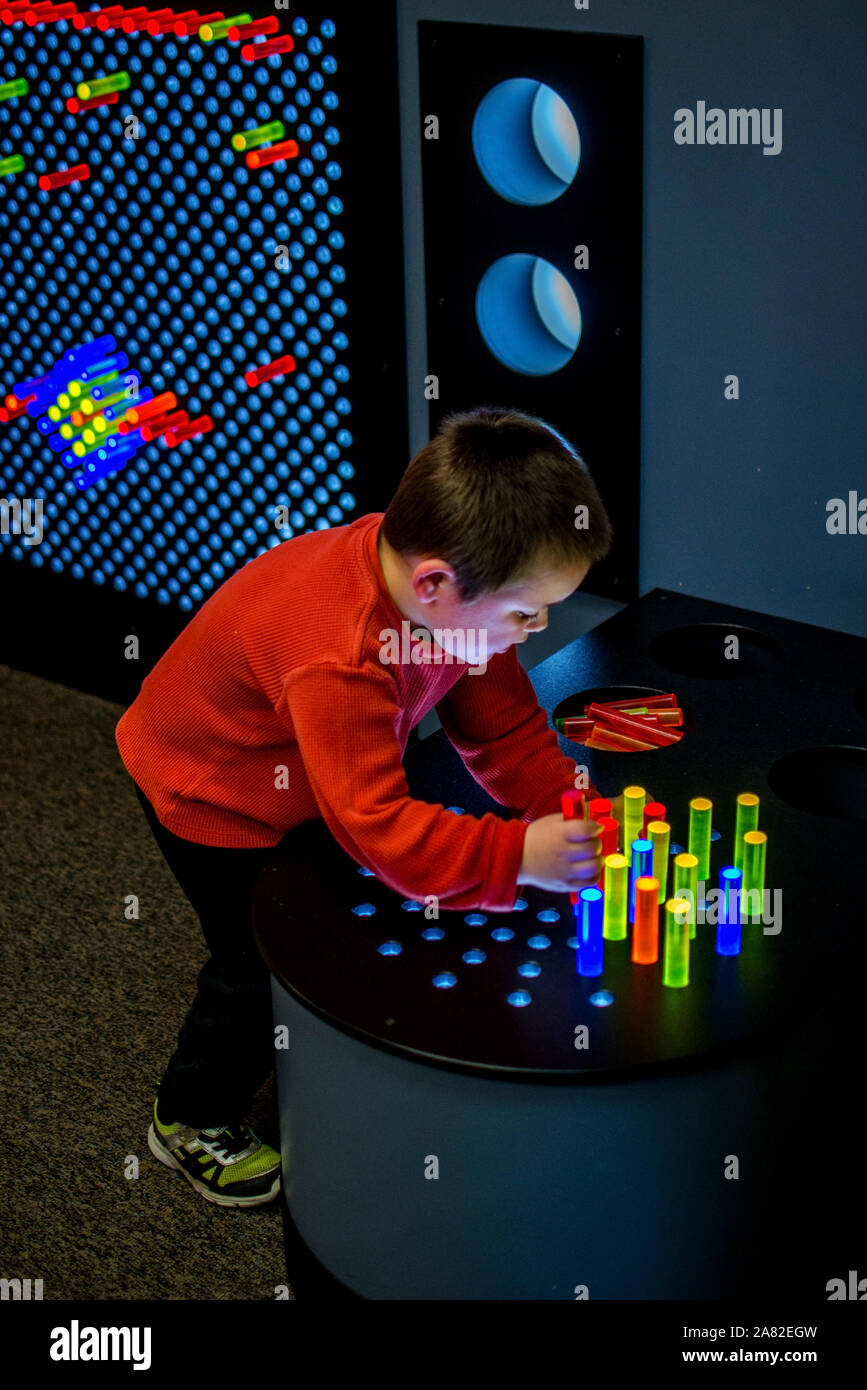 child playing with a colored pegs and light to create patterns and pictures Stock Photo