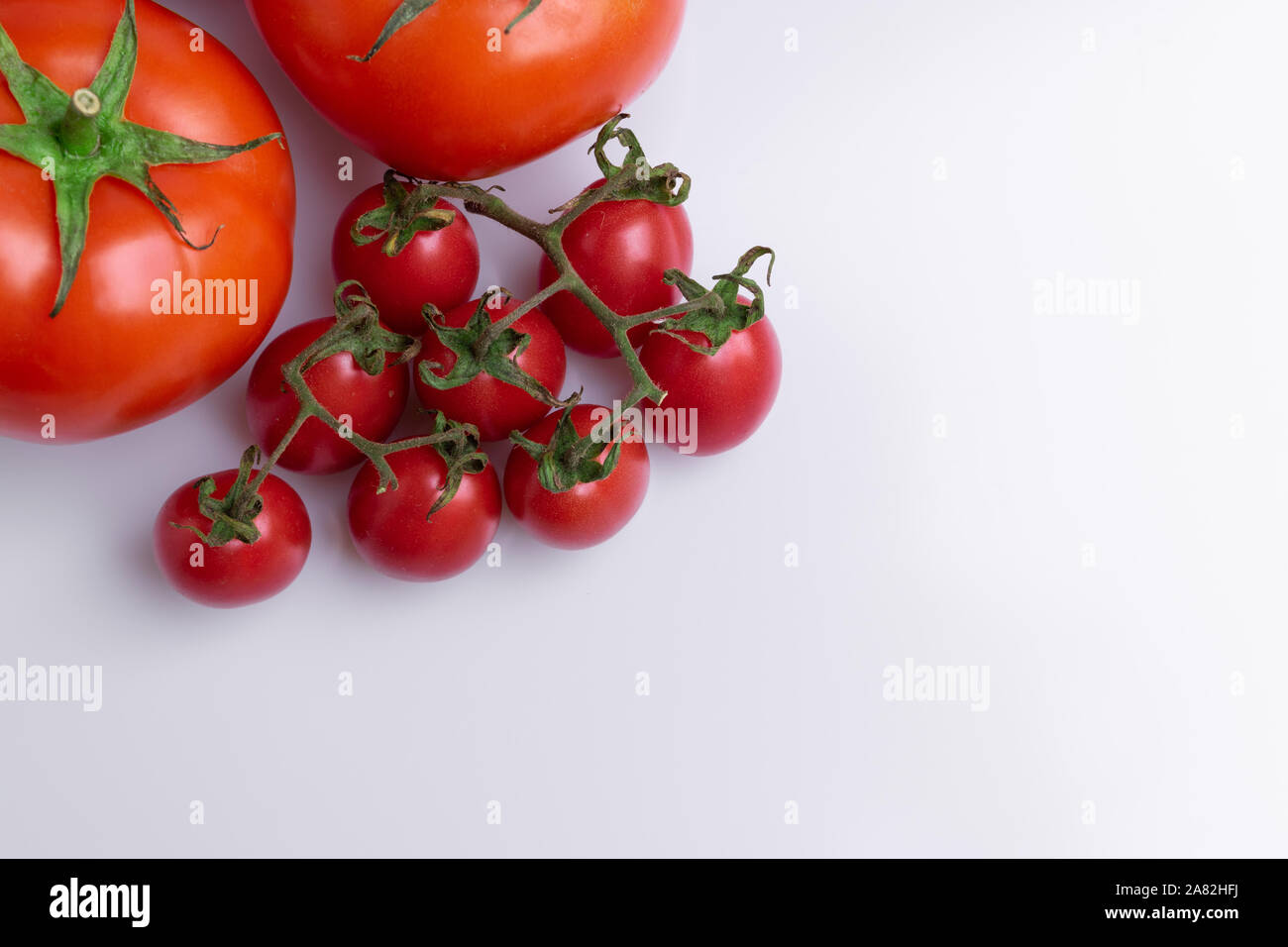 Grape or cherry tomato branch. Pile of red grape and normal tomatoes ...