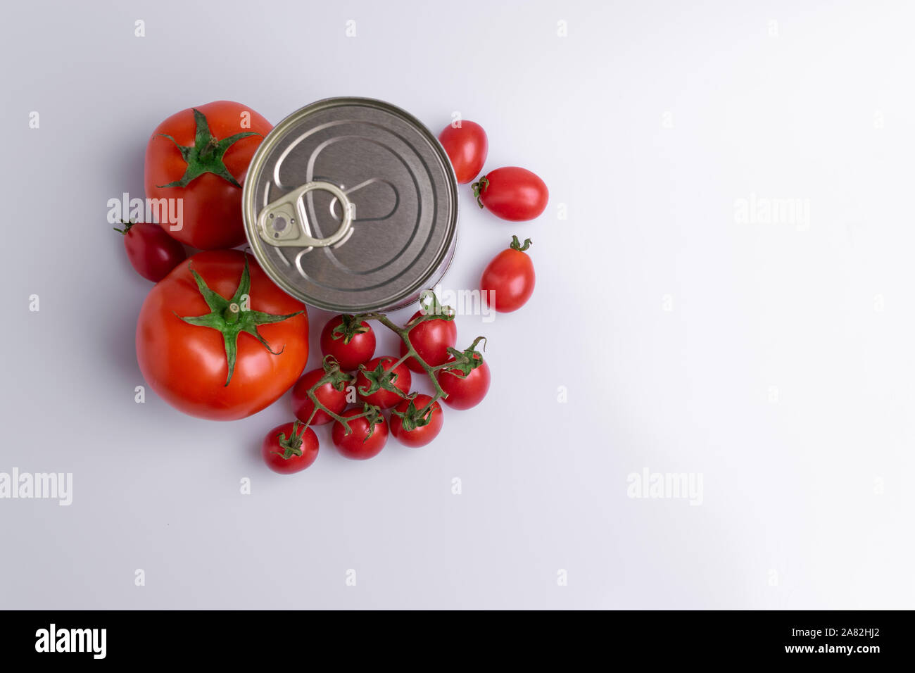 in of chopped canned tomatoes with whole fresh tomatoes, isolated on white background, soft light Stock Photo