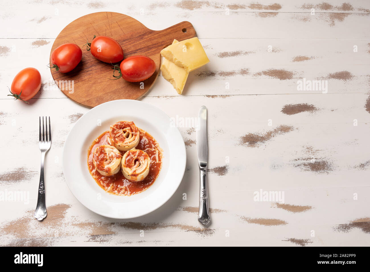 Traditional Italian Rondelli pasta with tomato sauce on rustic white wooden table background, soft light Stock Photo