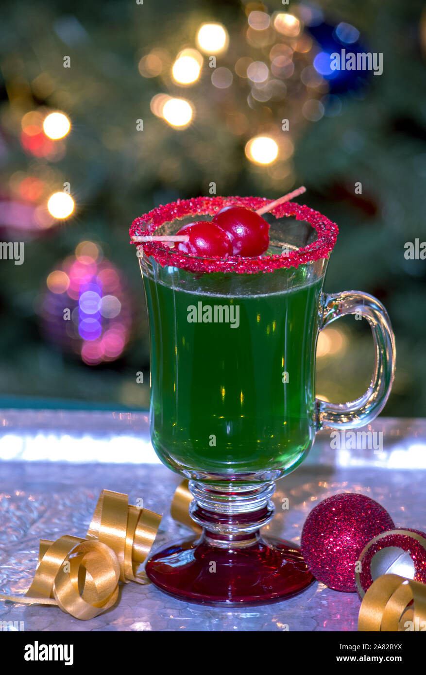 this green grinch drink with a red sugar rim and a cherry garnish, is the perfect holiday treat. made alcoholic or virgin for the kids ( no alcohol) t Stock Photo