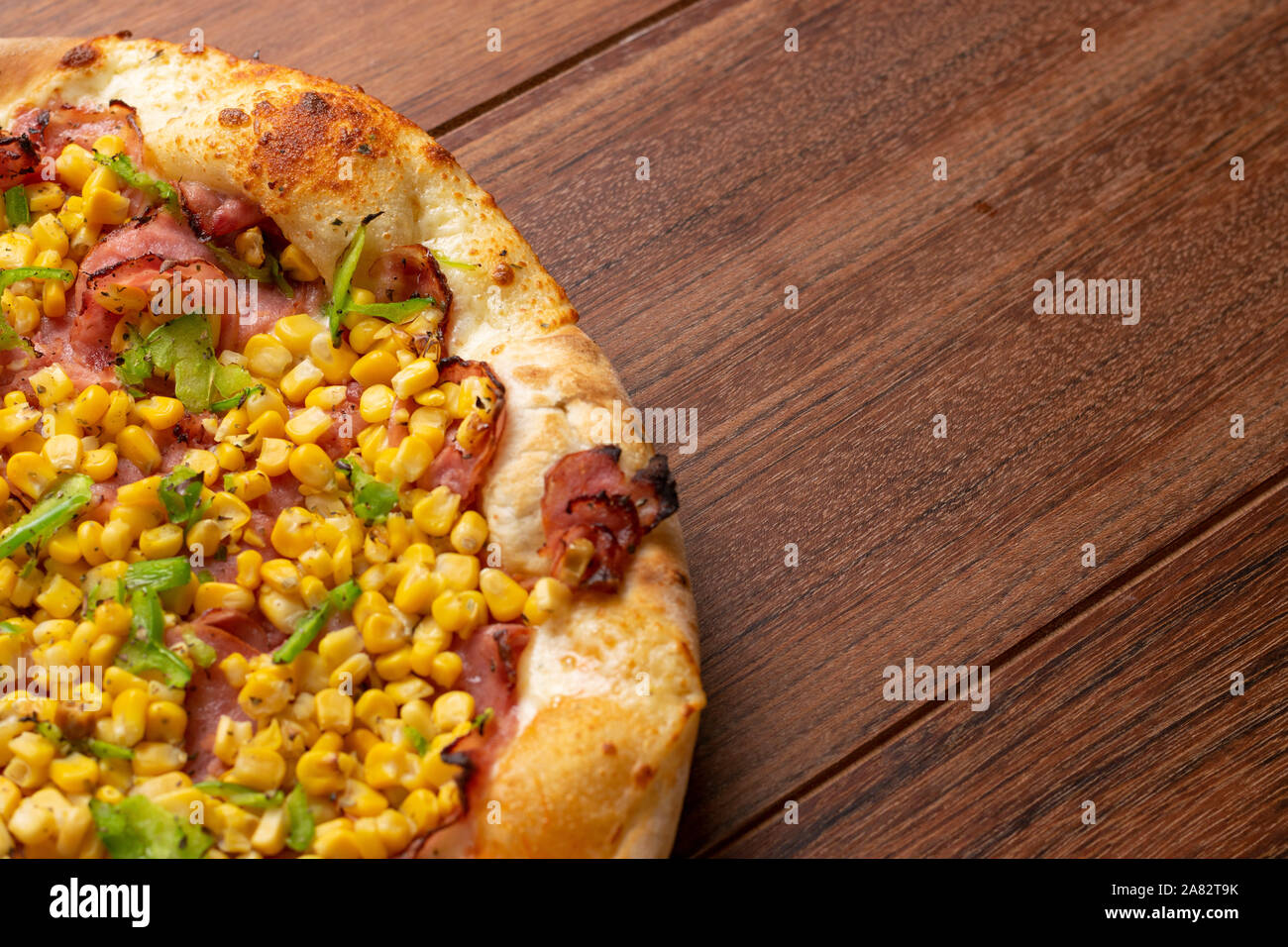 Pepperoni  and corn pizza on a wooden background. Top view. Flat view. Stock Photo