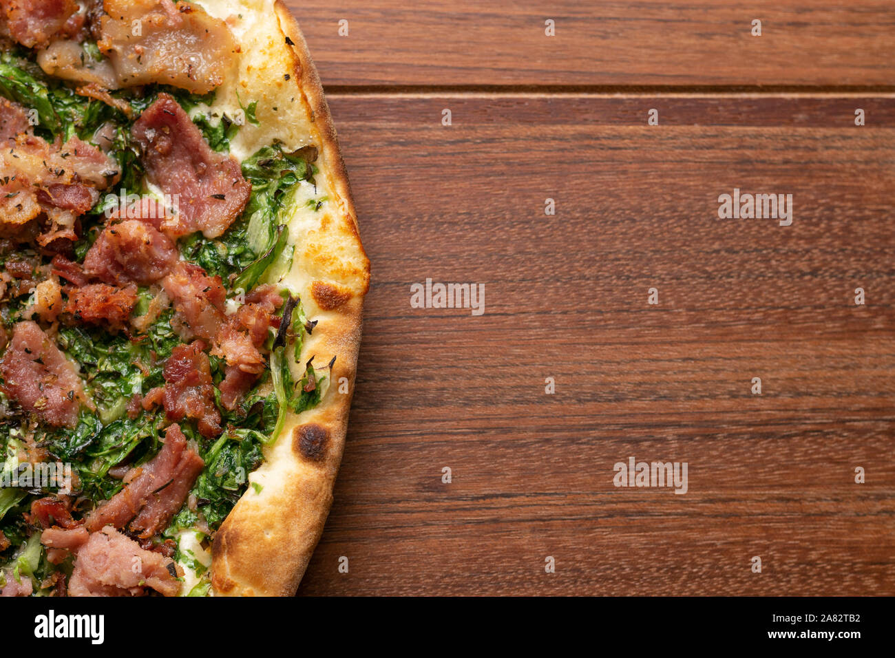 Pepperoni  and escarole pizza on a wooden background. Top view. Flat view. Stock Photo