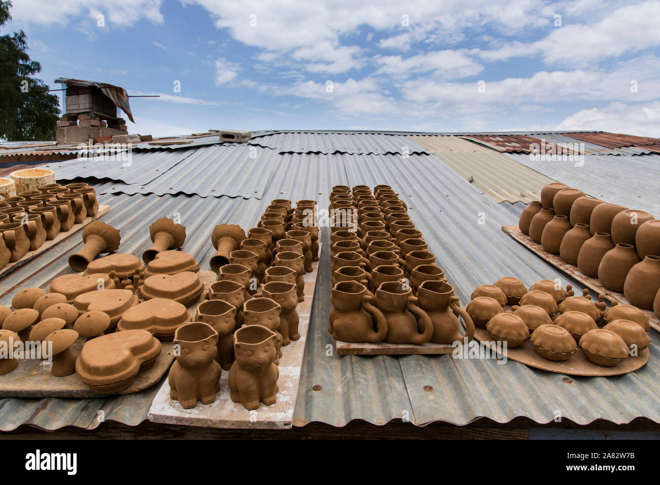 Unfired pottery or greenware dries on the tin roof of a pottery