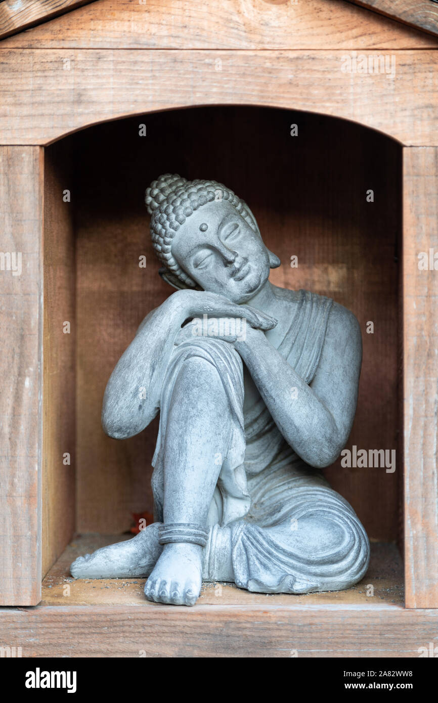 Closed eye resting Buddha with head and hands on knee, a variation of the more common Lotus Pose Stock Photo