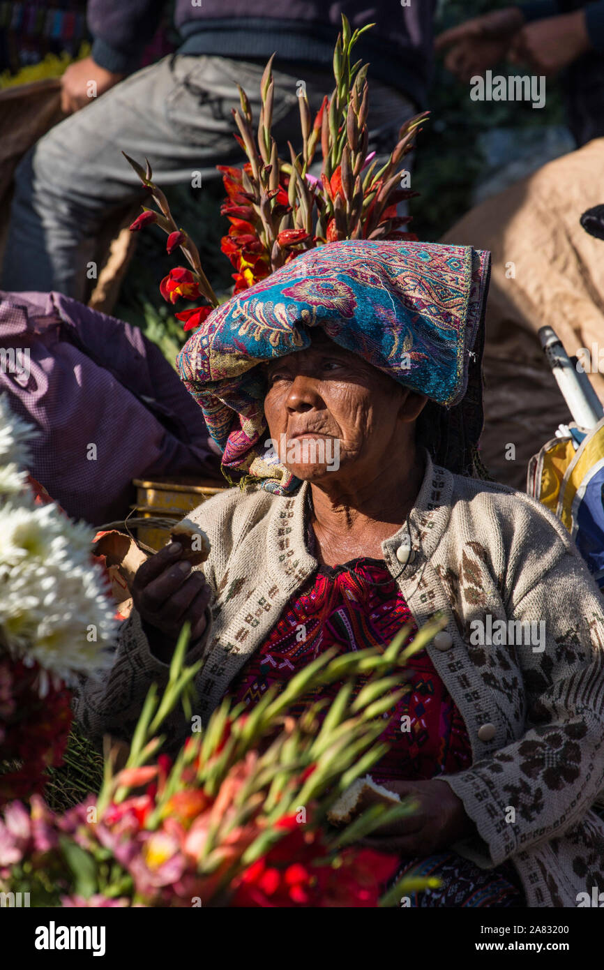 Quiche Mayan woman in traditional dress selling flowers on the steps of the Church of Santo Tomas in Chichicastenango, Guatemala. Stock Photo