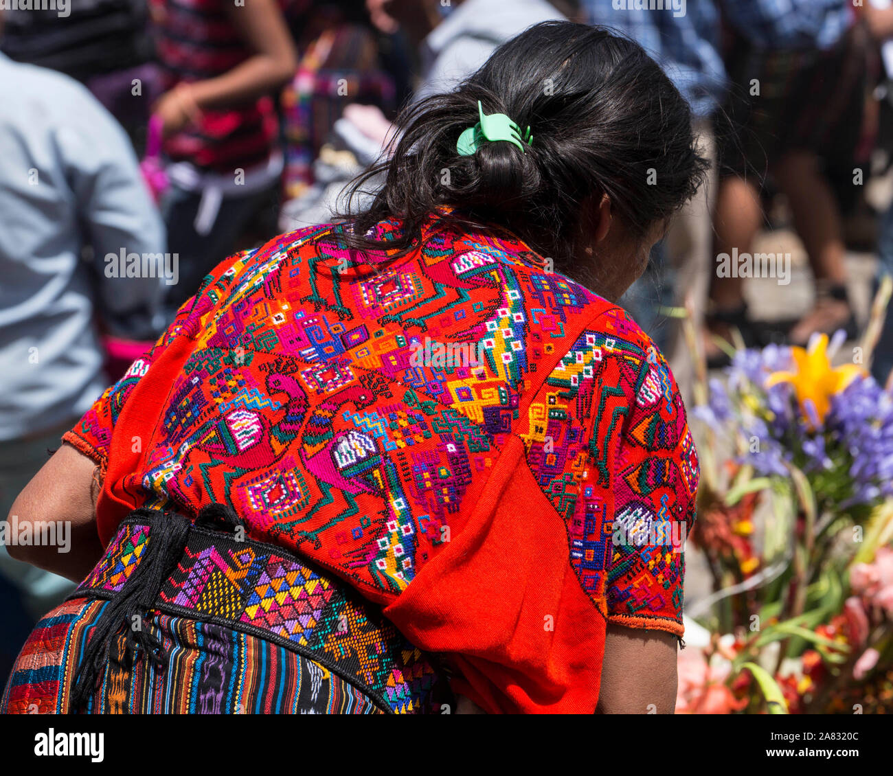 A woman at the Sunday market in Chichicastenango, Guatemala wears the traditional colorful woven huipil or blouse from that town. Stock Photo
