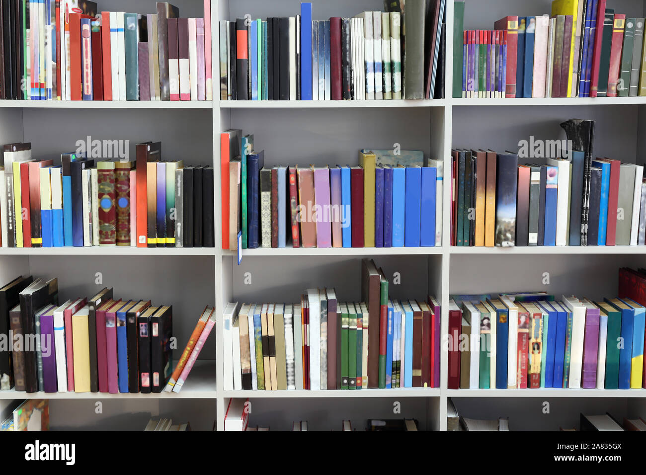 Many books on shelves in modern library Stock Photo - Alamy