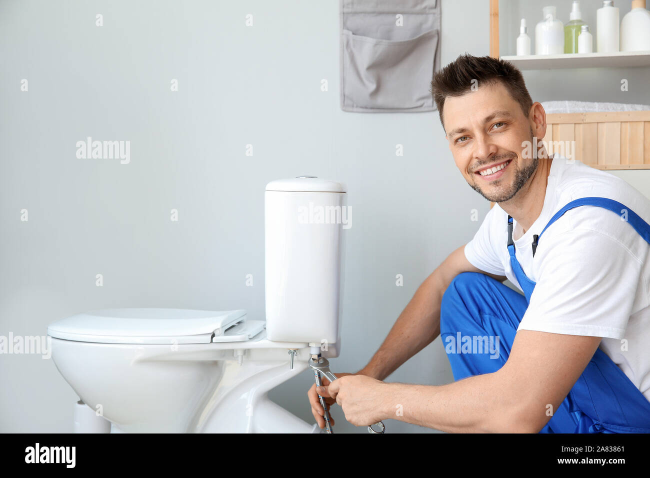 Plumber installing toilet in restroom Stock Photo Alamy