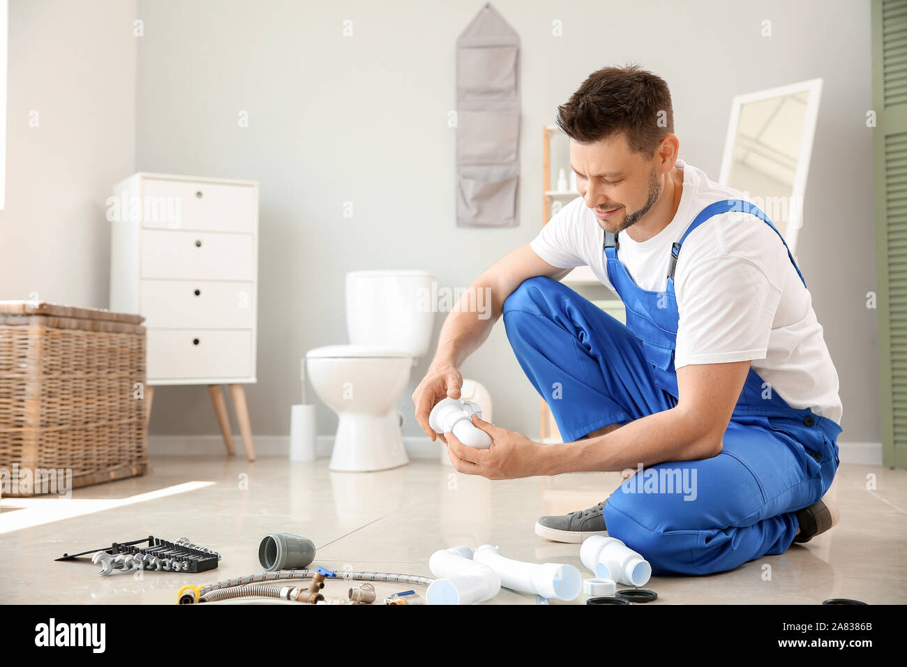 Handsome plumber working in restroom Stock Photo - Alamy