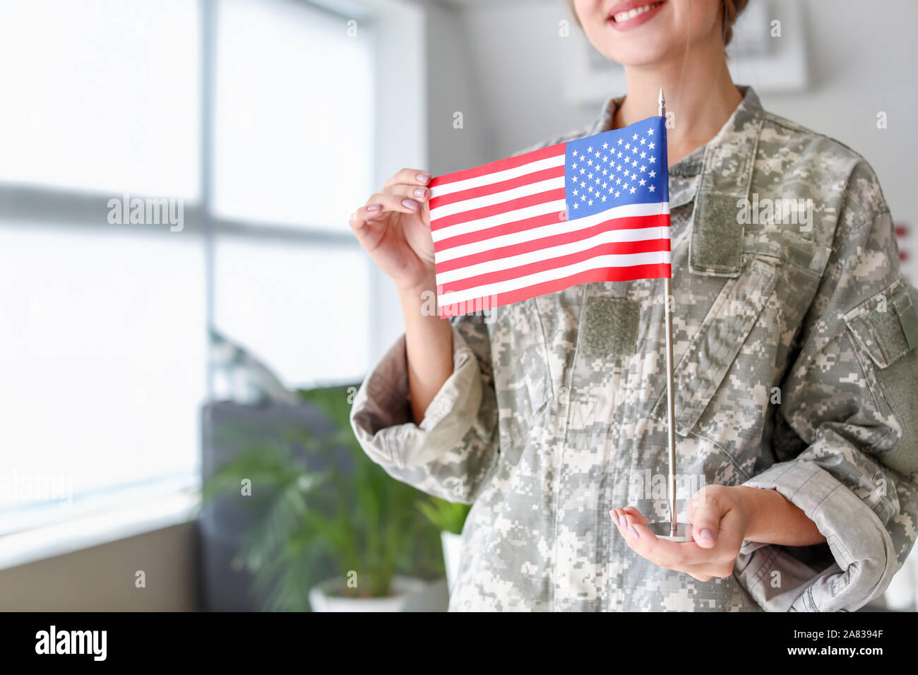 Young female soldier with USA flag in headquarters building Stock Photo ...