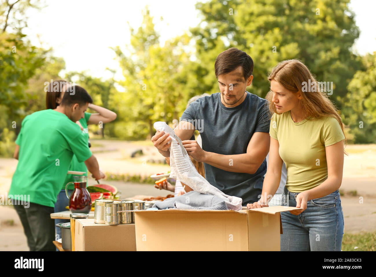 Poor people receiving new clothes from volunteers Stock Photo