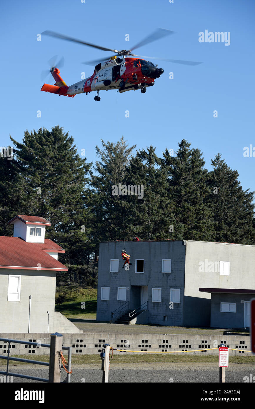 Petty Officer 3rd Class Bryan Evans, an aviation survival technician at Coast Guard Sector Columbia River, is lowered from an MH-60 Jayhawk helicopter to the open window of a building at the Camp Rilea Military Operations in Urban Terrain Village in Warrenton, Ore., Nov. 1, 2019. This urban search and rescue training evolution was conducted in conjunction with members of Aviation Training Center Mobile. (U.S. Coast Guard photo by Petty Officer 3rd Class Trevor Lilburn) Stock Photo