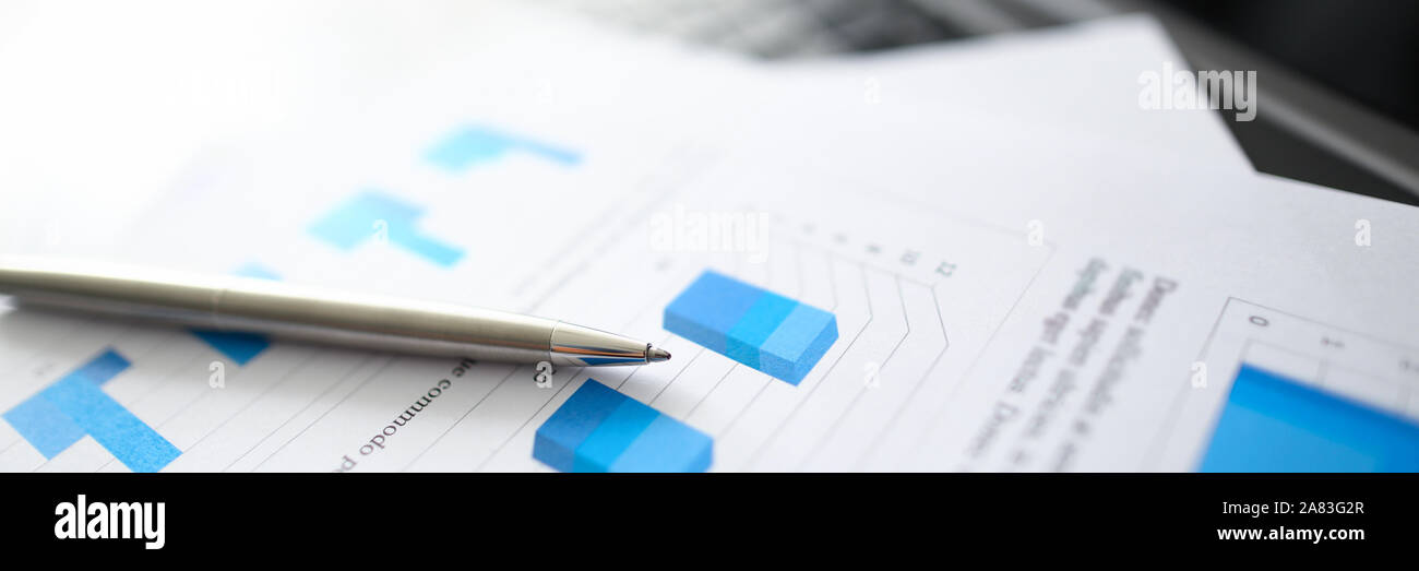 A silver pen lies on documents with Stock Photo