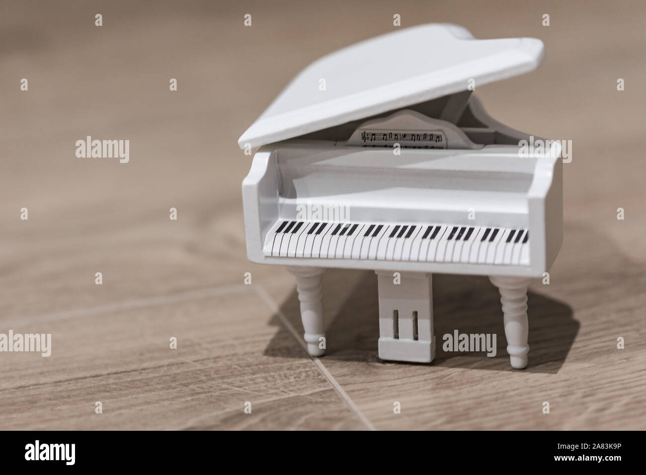 Tiny white toy piano music macro still isolated on a wooden background  Stock Photo - Alamy