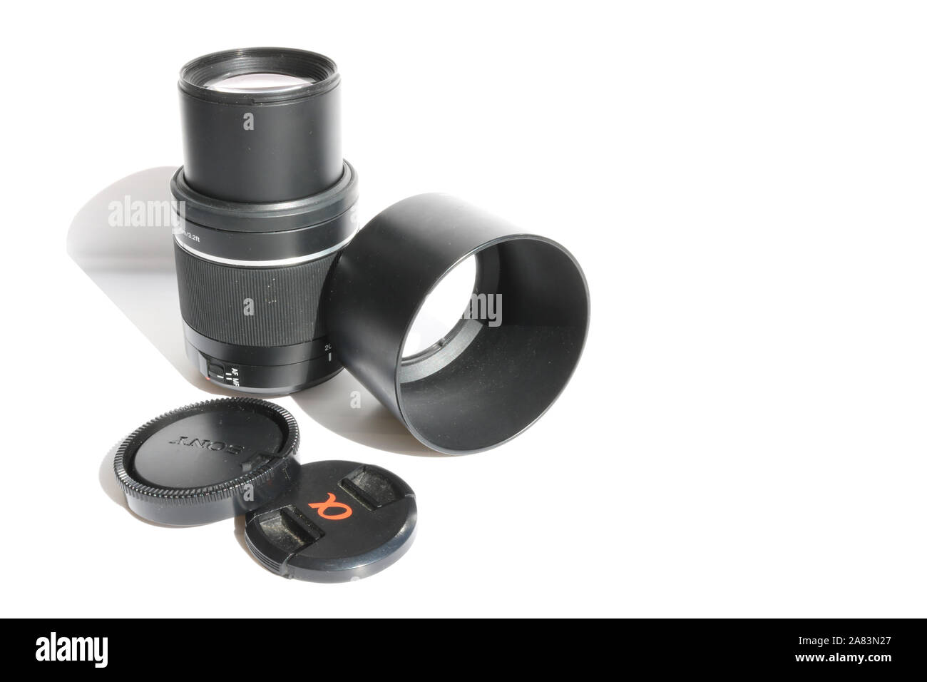 SLR telephoto lens and accessories - lens hood, cap on a white background. Stock Photo
