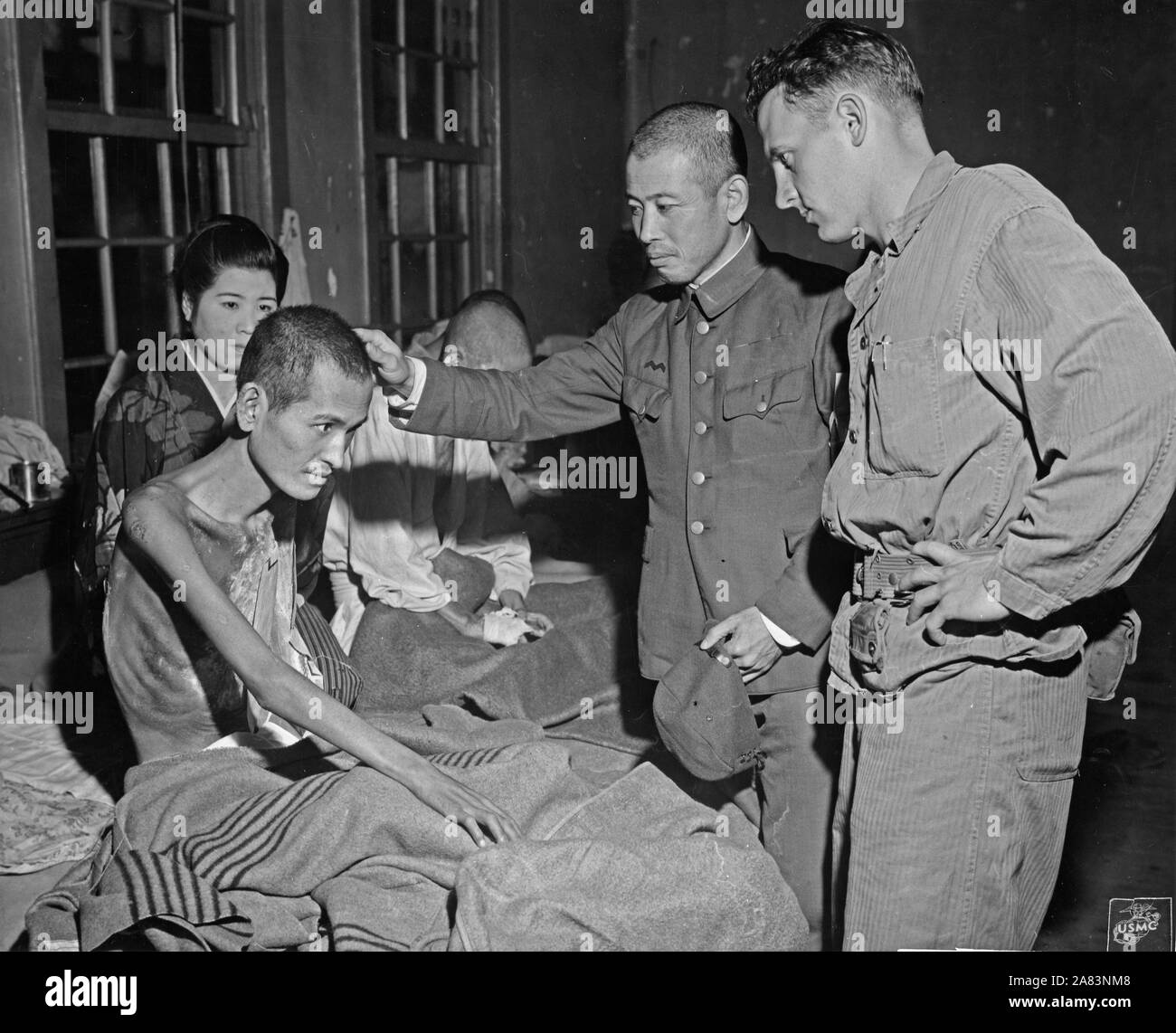 Navy Lt confers with head of Saga General hospital about flash burns on a victim of bombing in Nagasaki Japan Stock Photo