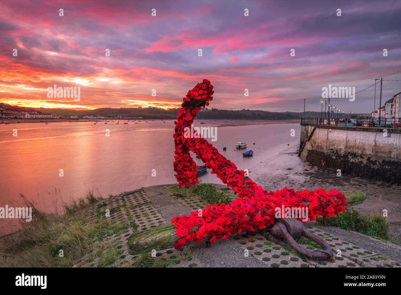Appledore, North Devon, England. Wednesday 6th November 2019. UK Weather. After a cold night there was a  colourful sunrise over the River Torridge estuary at Appledore in North Devon. The landmark anchor at Appledore has been covered by the local community with knitted poppies in preparation for the forthcoming Remembrance Sunday. Terry Mathews/Alamy Live News. Stock Photo