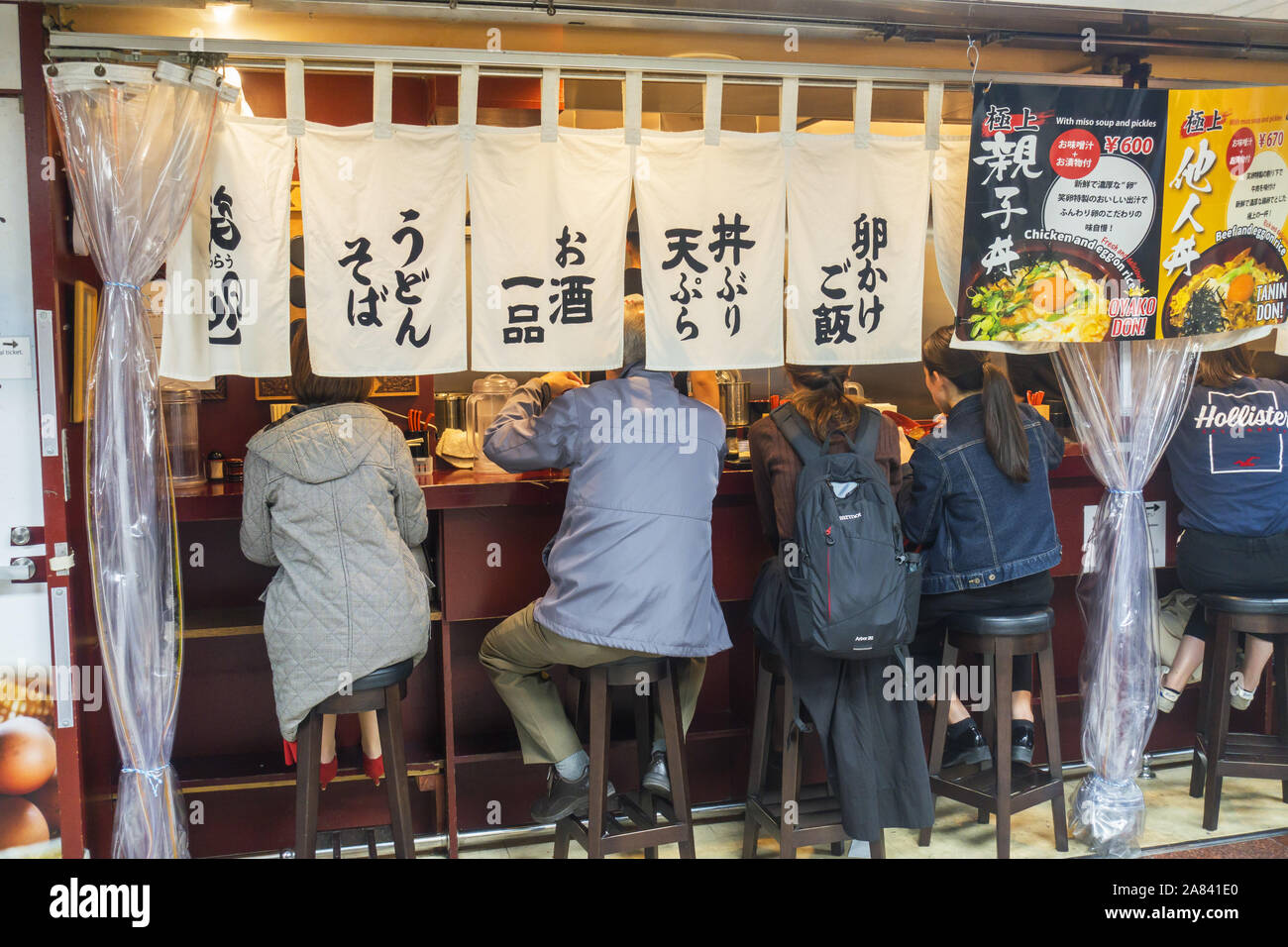 Osaka, Japan - November 3rd, 2019: People eating in Izakaya, a type of informal Japanese pub and casual place for after-work drinking. Stock Photo