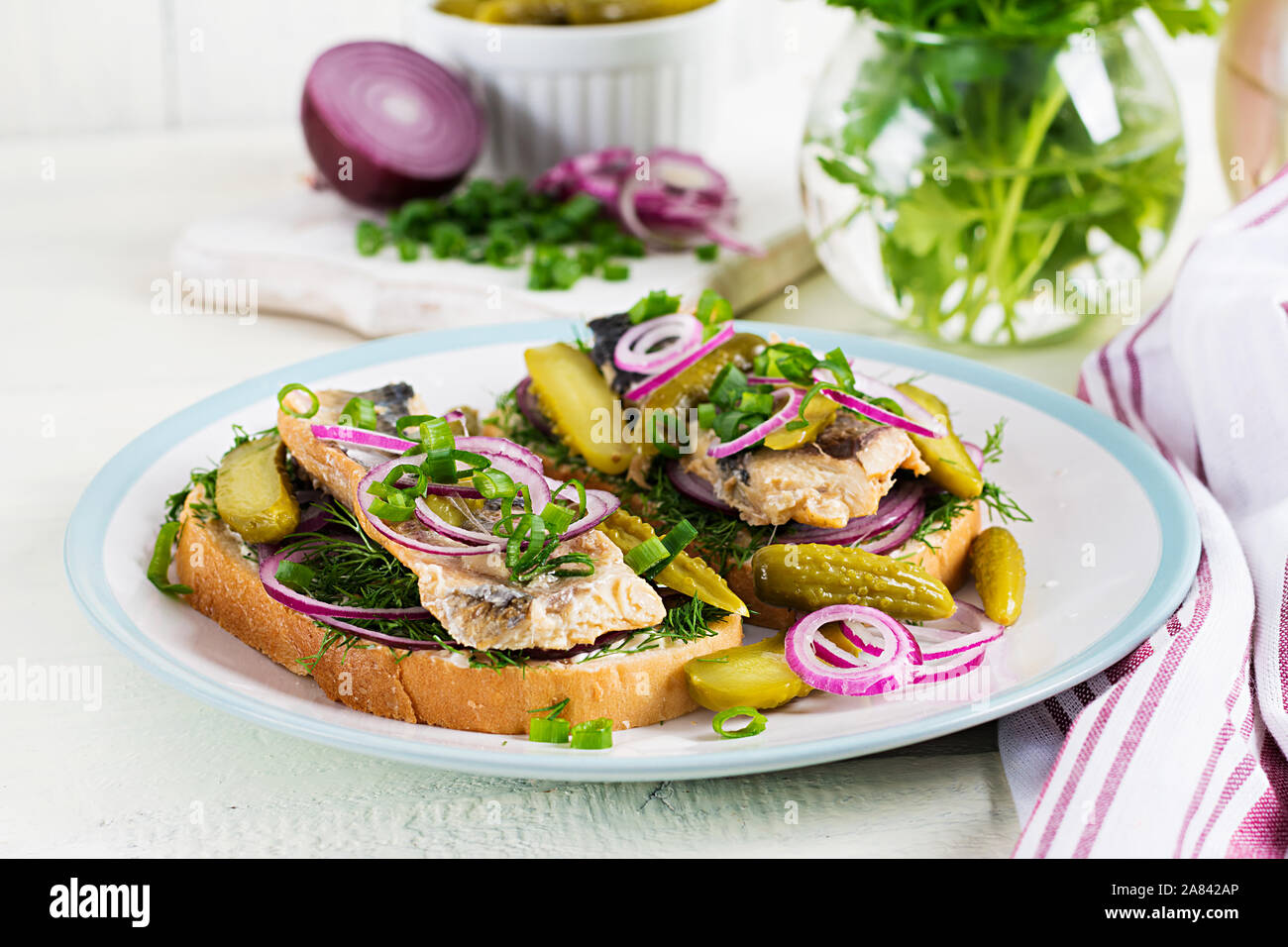 Traditional Dutch sandwich with herring and pickles cucumbers on white